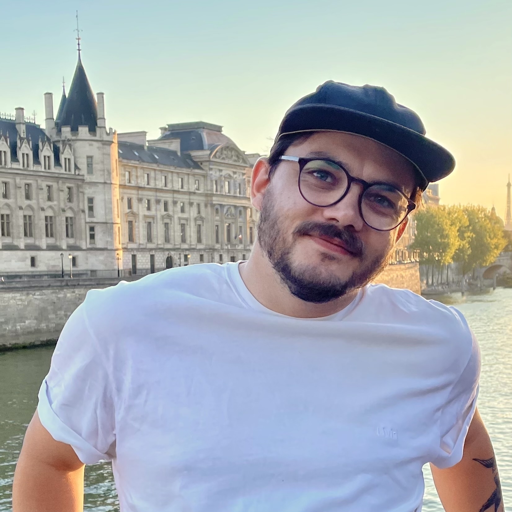 Me standing infront of the Sein in Paris, with a white t-shirt and the cap.
